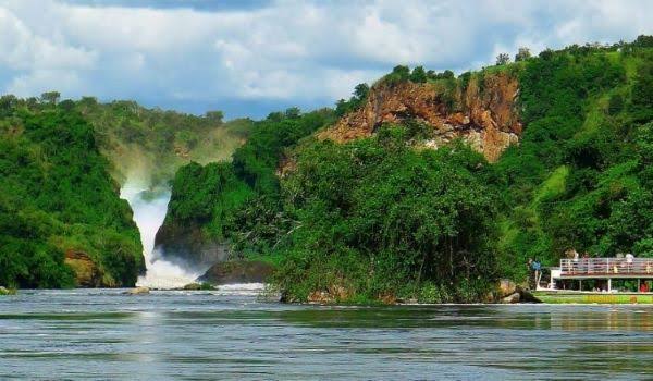 Tourists on a boat cruise approaching the base of Murchison Falls, the highlight of any safari in Uganda Murchison Falls.