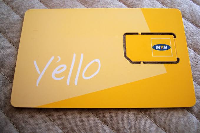 Buying MTN SIM card Entebbe airport arrivals – tourist inserting SIM card into phone