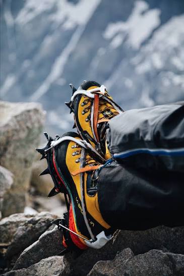 Checking crampon fit on mountaineering boots during ice axe and crampon rental in Kampala for Margherita Peak