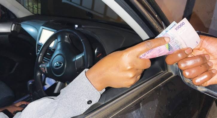 Driving in Uganda police bribe traffic stop – police officer speaking with a driver