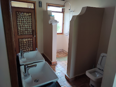 Hot water flush toilet facilities Uganda safari camps – traditional bucket shower at a basic camp
