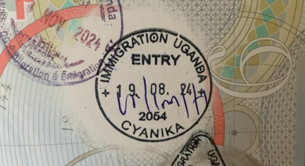 Passport being stamped during the Kigali to Bwindi border crossing at the Uganda immigration office