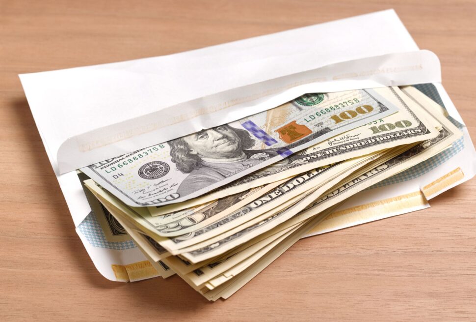 Paying Uganda safari USD vs UGX shillings – US dollars and Ugandan shillings banknotes