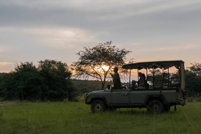 Tipping park ranger guide Uganda game drive – park ranger receiving a tip on a game drive