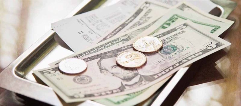 Uganda safari guide tip amount per day – safari guide receiving a tip from a tourist
