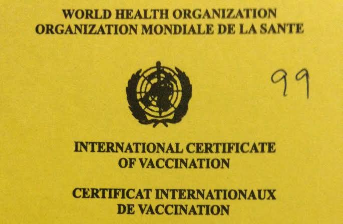 Uganda immigration officer reviewing yellow fever vaccine exemption certificate for Uganda entry at airport