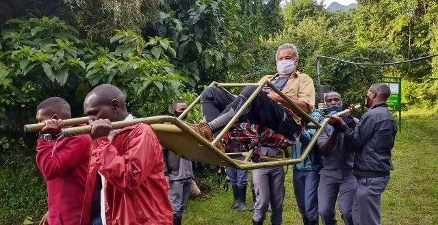 Sedan chair team carrying a trekker on the Bwindi forest trail